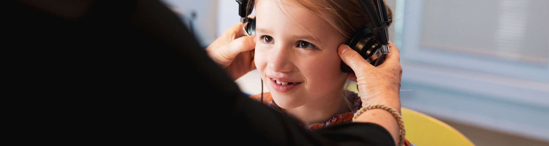 Kind krijgt koptelefoon op voor gehooronderzoek