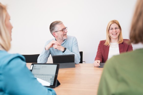 Vier collega's van een audiologisch centrum aan tafel in gesprek met elkaar